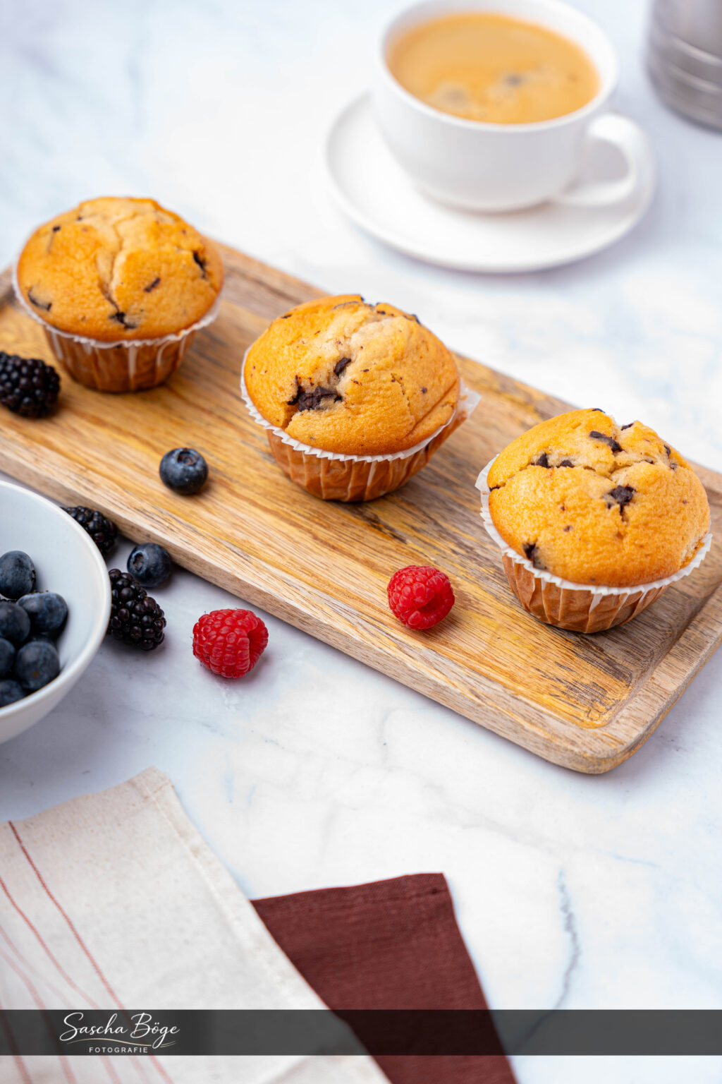 Frische Muffins auf Holzbrett – Bäckerei-Fotografie für Online-Auftritt